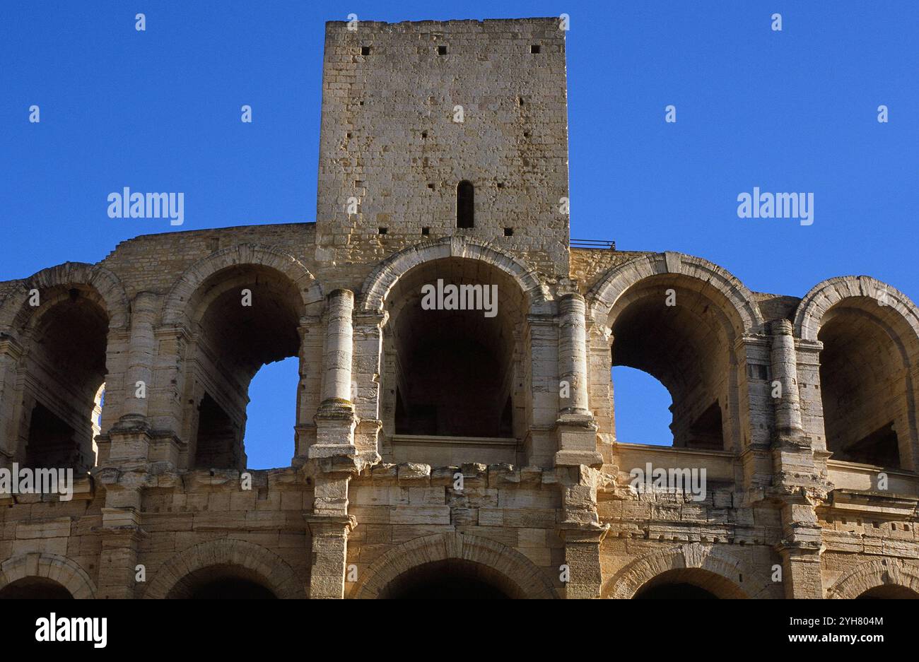 Die Bögen und der mittelalterliche Turm sind Teil des römischen Amphitheaters in Arles, Provence, Frankreich Stockfoto