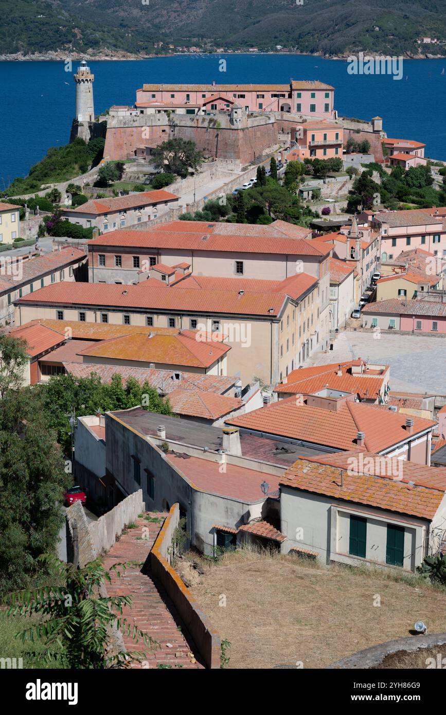 Perspektivischer Blick auf die Stadt Portoferraio auf der Insel Elba in Italien, mit einem roten Auto in einer Gasse und den Dächern des Dorfhauses Stockfoto