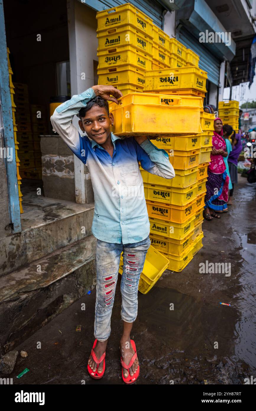 Ein Junge, der sich um Kisten kümmert, Ambuji, Gujarat, Indien Stockfoto