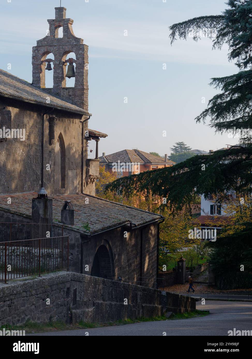 San Flaviano (Saint Flavian) historische Kirche mit ihrem Glockenturm als Fußgänger in der Stadt Montefiascone vorbei spazieren. Nov. 2024 Stockfoto