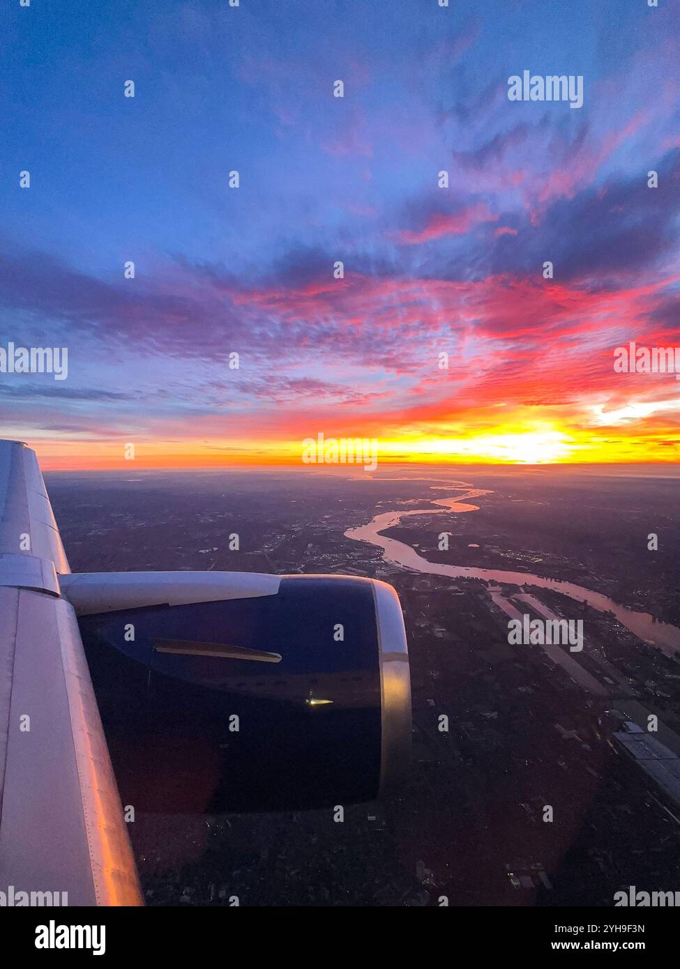 Sonnenaufgang über dem Horizont durch das Fenster eines Urlaubsjets Stockfoto