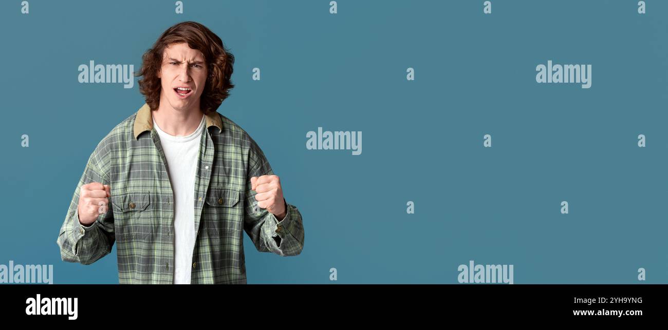 Konfliktkonzept. Gestresster, tausendjähriger Kerl, der Fäuste auf dem Farbhintergrund klungen Stockfoto