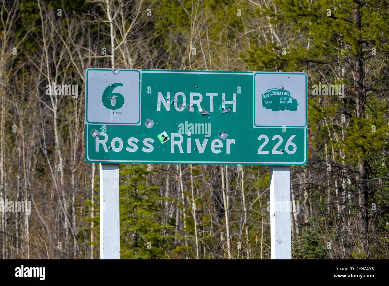 Straßenschild Ross River im Norden Kanadas, Yukon Territory im Sommer mit Schusslöchern in Straßenschildern. Stockfoto