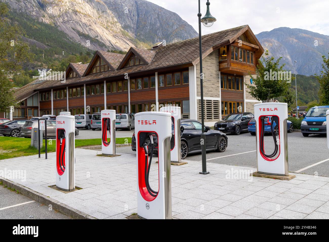 Bank of Tesla Supercharger im Dorfzentrum von Eidfjord produzieren diese Superlader bis zu 150 kW beim Laden von Fahrzeugen, Westnorwegen, Europa 2024 Stockfoto