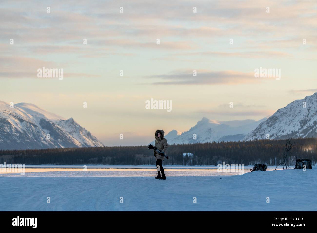 Riesige, wunderschöne, schneebedeckte Berge im Hintergrund mit Frauen in voller Winterkleidung, die im Vordergrund auf dem gefrorenen See stehen. Stockfoto Riesige, wunderschöne, schneebedeckte Berge im Hintergrund mit Frauen in voller Winterkleidung, die im Vordergrund auf dem gefrorenen See stehen. Stockfoto