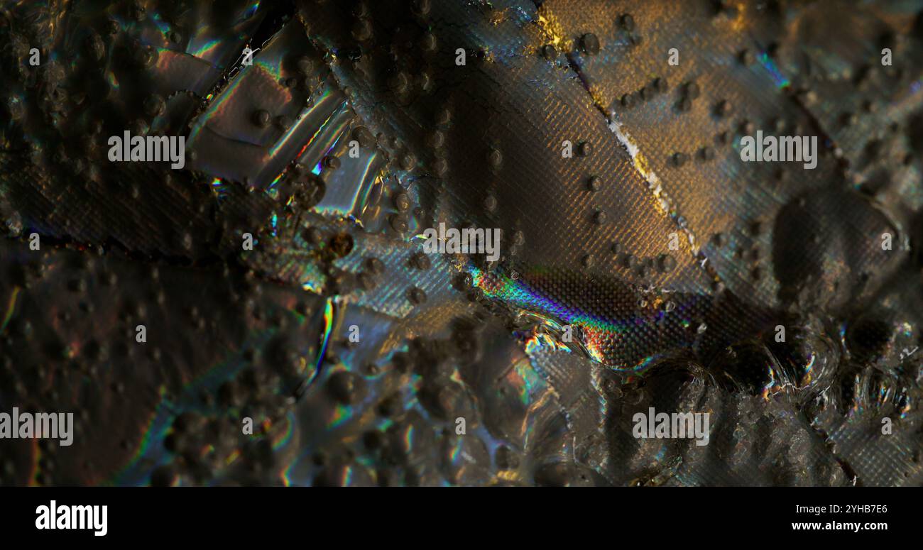 Fantastische Oberfläche. Nasse Highlights. Stoffstruktur mit schillerndem Licht. Rauer silberner Hintergrund mit glitzernden Flecken in wechselnder Farbe im Regenbogeneffekt. Stockfoto