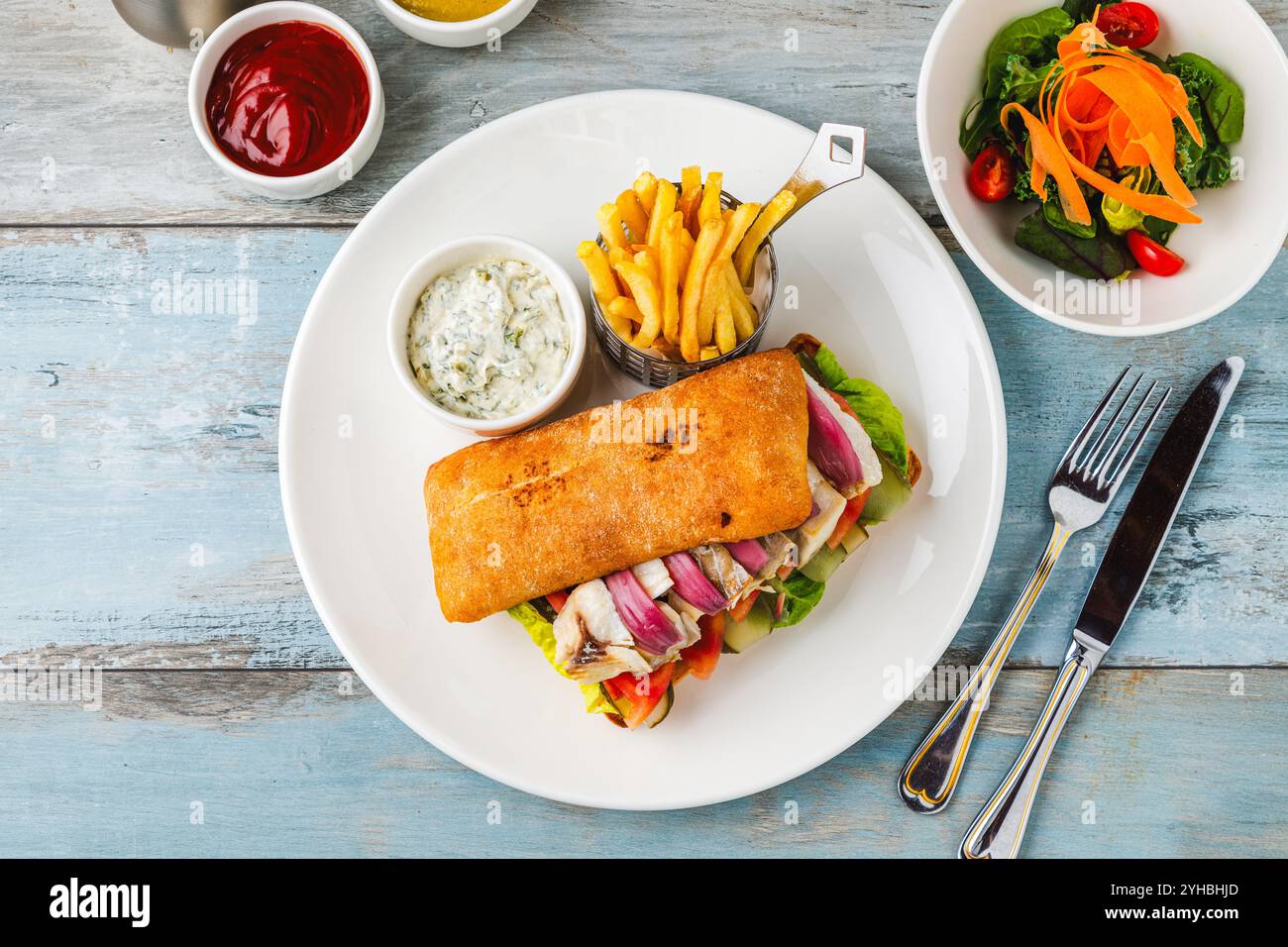 Gegrilltes Fisch-Sandwich mit roten Zwiebeln. Mit Pommes frites und Sauce Stockfoto