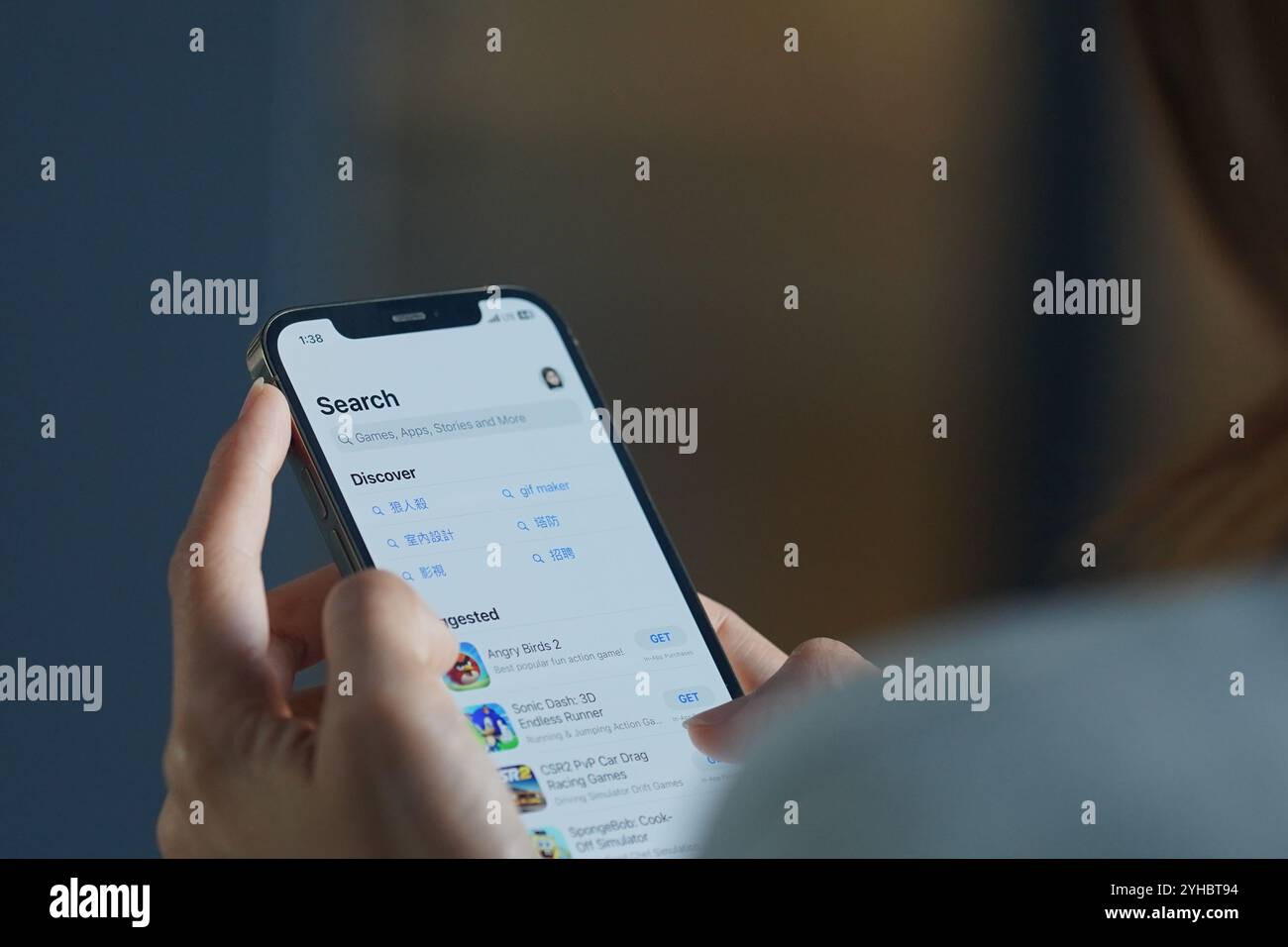 In dieser Fotoabbildung durchsucht Eine Frau auf ihrem iPhone den App Store (Apple), um genehmigte Apps auf dem App-Markt herunterzuladen. Stockfoto