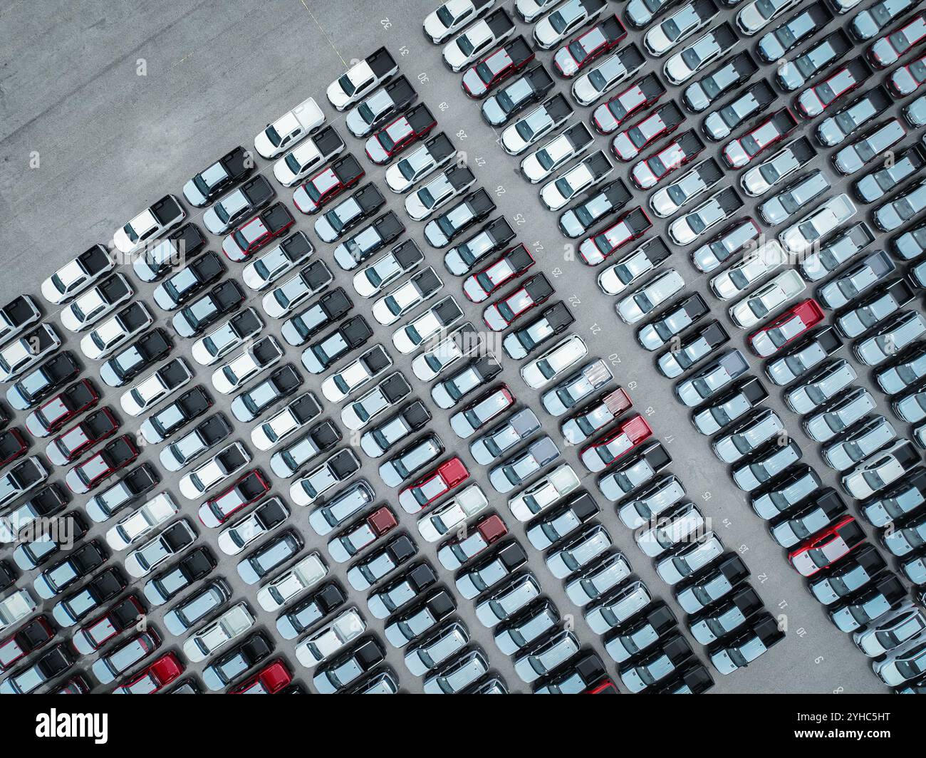 Luftaufnahme des Bestands neuer Autos auf einem großen Fabrikparkplatz. Automobilindustrie, Logistikbetrieb und Fahrzeuglagerung für Import und Export. Ke Stockfoto