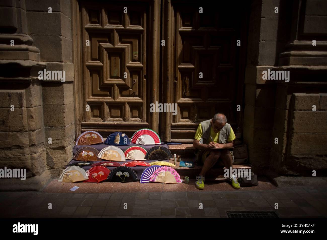 Ein Mann malt Handfans in einer Straße in Malaga, Andalusien, Spanien. Stockfoto