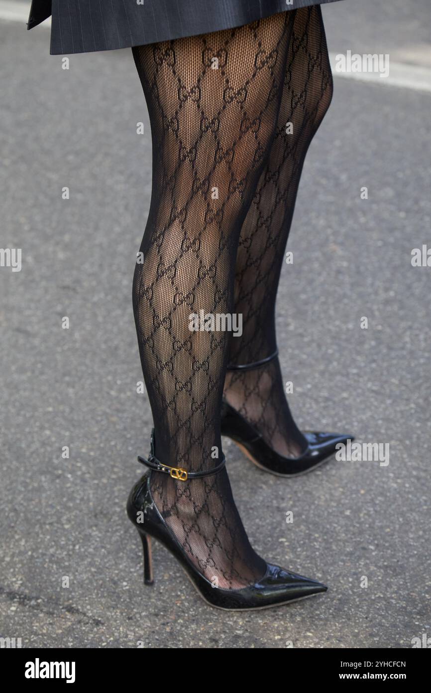 MAILAND, ITALIEN - 20. SEPTEMBER 2024: Frau mit schwarzen Gucci-Strümpfen mit Logo-Muster und Schuhen mit hohem Absatz vor der Gucci-Modenschau, Milan Street styl Stockfoto
