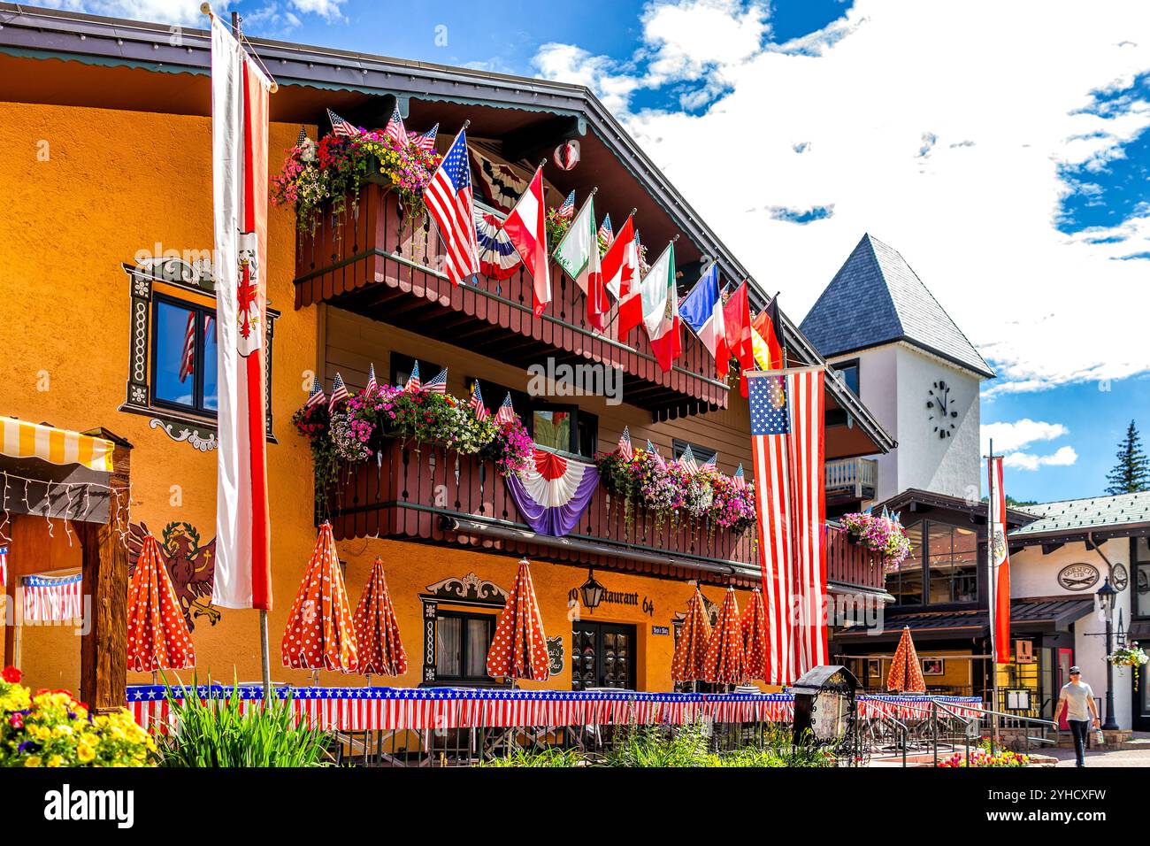 Vail, USA - 3. Juli 2022: Einkaufsstraße des Colorado Ski Resort Town Square mit internationalen Flaggen europäischer amerikanischer Länder auf Balkon Stockfoto