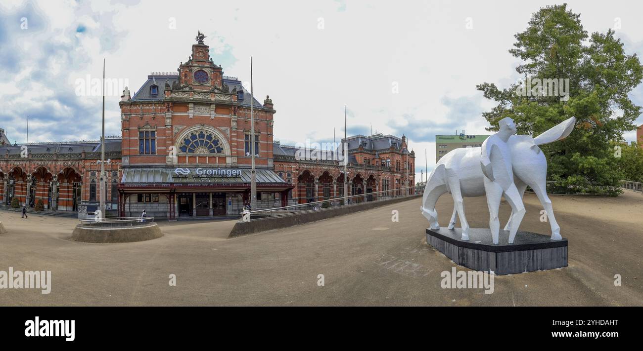 Panoramaaufnahme der Skulptur Peerd van OME Loeks und des imposanten Gebäudes Groningen Central Station, Groningen, Provinz Groningen, Niederlande Stockfoto