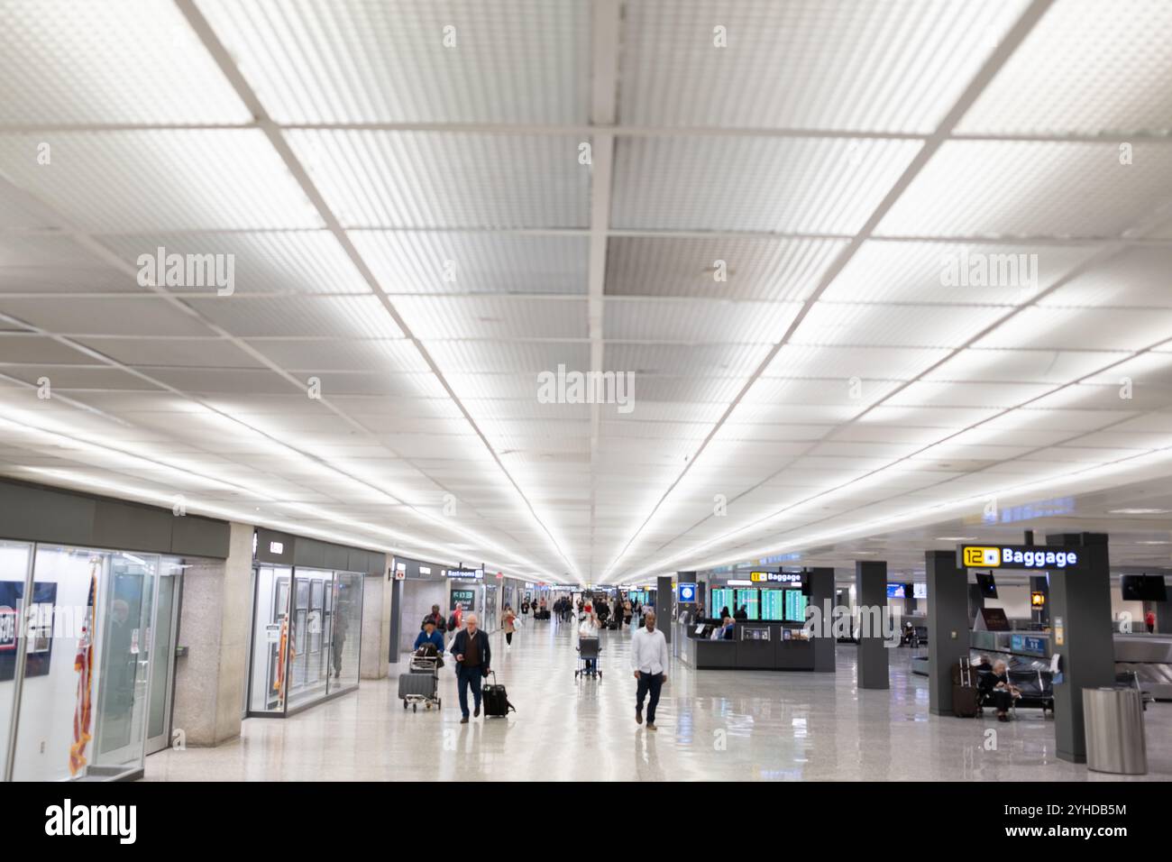 Gepäckausgabebereich Dulles International Airport Virginia // DULLES, Virginia — der Gepäckausgabebereich am Washington Dulles International Airport (IAD) verfügt über mehrere Karussellsysteme, mit denen ankommende Passagiere ihr Gepäck abholen können. Der Bereich befindet sich im unteren Stockwerk des Hauptterminals und verfügt über elektronische Informationsanzeigen mit Flugnummern und zugewiesenen Karussellzuweisungen. In der Nähe befinden sich Serviceschalter von Fluggesellschaften, die Reisenden bei Fragen zum Gepäck behilflich sind. Für Passagiere, die mehrere Personen transportieren, stehen im gesamten Bereich kostenlose Gepäckwagen zur Verfügung Stockfoto