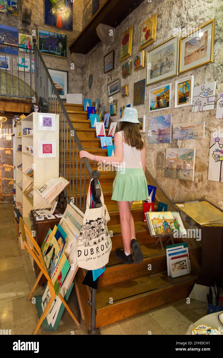 Kinder / Kinder / Mädchen, die Souvenirs aus Zimmern innerhalb der Stadtmauer kaufen; Altstadt von Dubrovnik, Kroatien. (138) Stockfoto