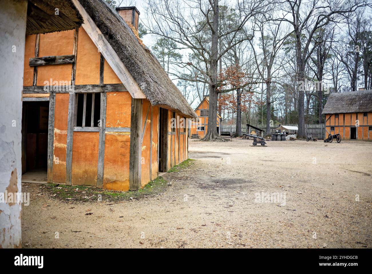 JAMESTOWN, Virginia – das nachgebildete James Fort in Jamestown Settlement verfügt über markante oranfarbene Flechtanlagen und Daub-Gebäude, die entlang unbefestigter Wege angeordnet sind. Der Grundriss des Forts zeigt typische englische Kolonialarchitektur und Siedlungsplanung des frühen 17. Jahrhunderts. Die Gebäudeanordnung spiegelt die Verteidigungskonzepte und praktische Überlegungen der ursprünglichen Festung in ihren dreieckigen Palisadenmauern wider. Stockfoto