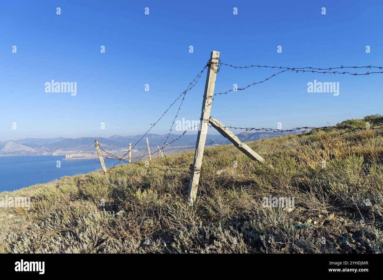 Zaun der verlassenen Militärbasis auf dem Gipfel des Berges über dem Meer. kap Meganom, Krim Stockfoto