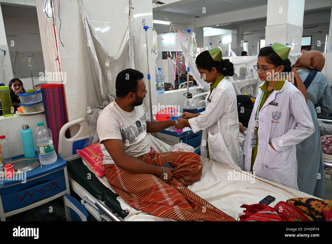 Dhaka, Bangladesch. November 2024. Krankenschwester behandelt einen Patienten, der mit Moskitonetzen bedeckt ist und an Dengue-Fieber leidet, ruhen Sie sich am 11. November 2024 im „Shaheed Suhrawardy“ Medical College Hospital in Dhaka, Bangladesch. Seit dem 1. Januar 2024 bis zum 11. November 2024 sind insgesamt 75.142 Menschen von Dengue betroffen. Mindestens 310 Menschen sind bei Bangladeschs schlimmstem Dengue-Ausbruch aller Zeiten gestorben, sagten Beamte am 11. November, als überlastete Krankenhäuser kämpfen, Tausende von Patienten zu behandeln. Quelle: Mamunur Rashid/Alamy Live News Stockfoto