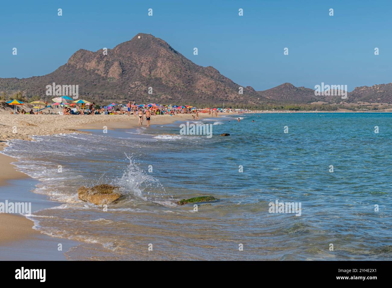 Am Sandstrand von Piscina Rei, Sardinien, Italien, stürzt eine Welle auf einen Felsen Stockfoto