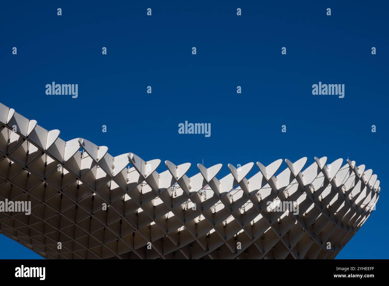 Die Spitze des Metropol Parasol in Sevilla erstreckt sich vor einem wolkenlosen Himmel und zeigt sein einzigartiges, modernes Design als ikonisches urbanes Wahrzeichen Stockfoto