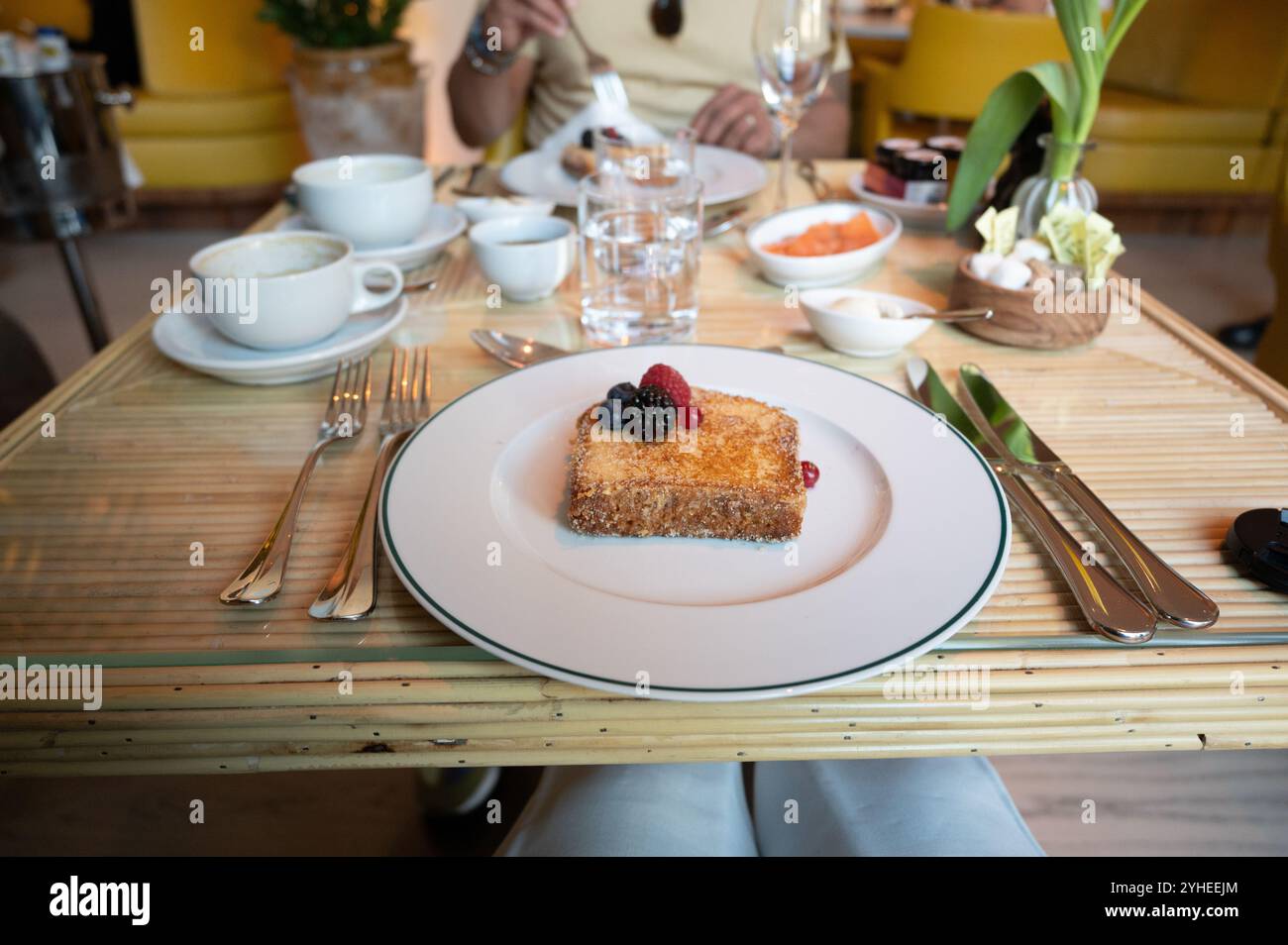 Ein gemütliches und intimes Frühstückslokal in einem Café in Madrid, wo ein Paar morgens ein frisch zubereitetes französisches Toast genießt Stockfoto