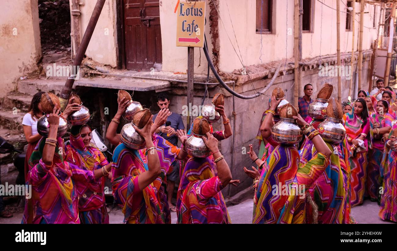 Die Brautparty bei einer Hochzeit tanzt durch die Straßen von Udaipur, während Einheimische und Touristen beobachten Stockfoto