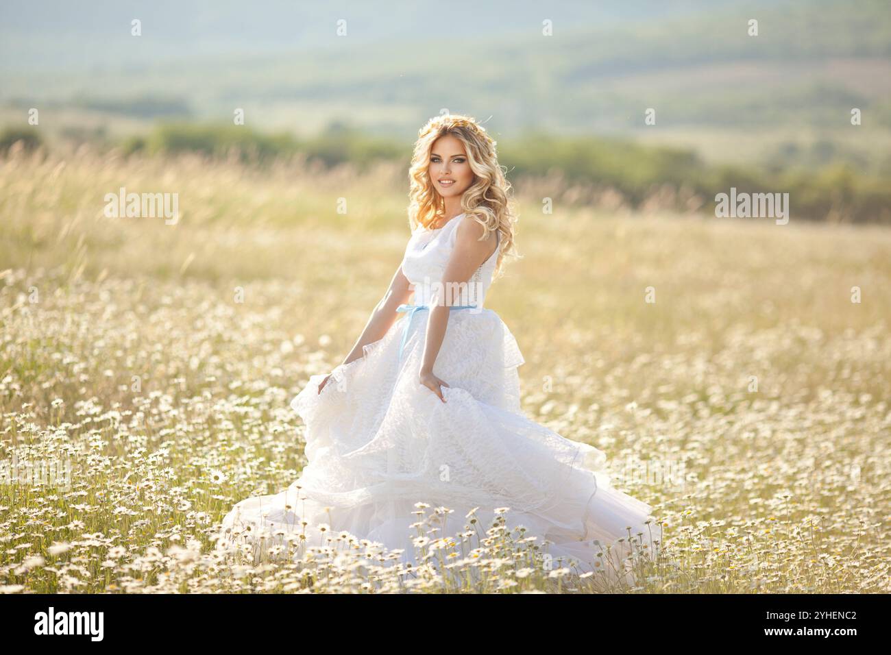 Schönes Mädchen, eine Blondine in einem alten weißen Kleid, läuft in einem blühenden Apfelgarten, ein Strauß von Anemonen, eine Braut Stockfoto