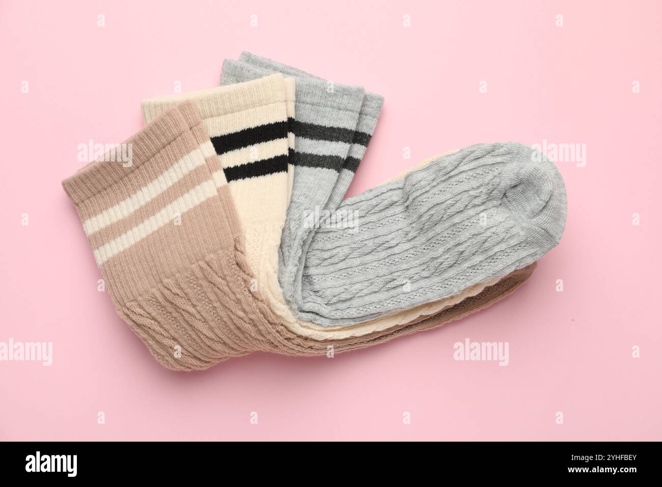 Verschiedene bequeme Socken auf hellrosa Hintergrund, Draufsicht Stockfoto
