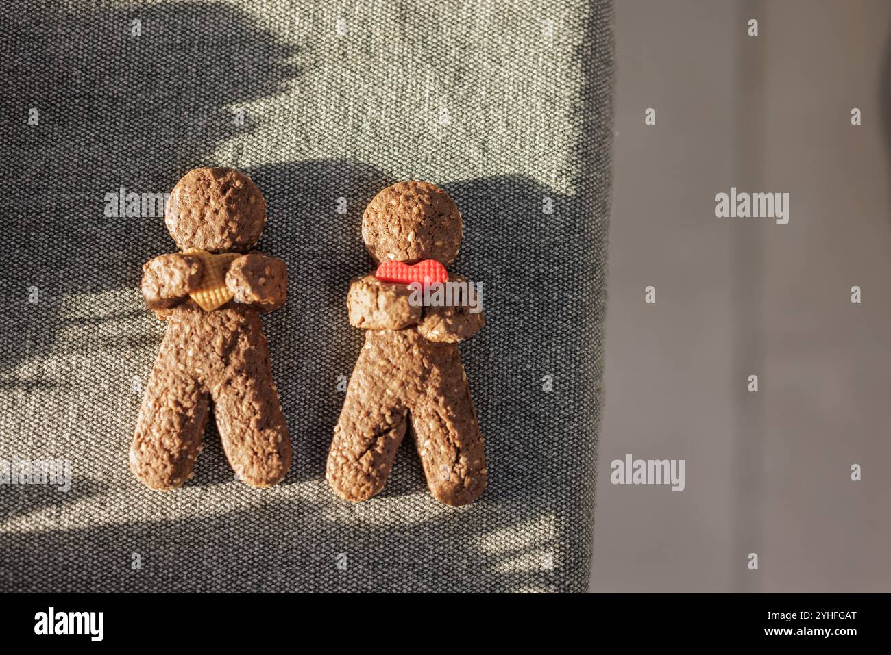 Hausgemachte Weihnachtskuchenmänner, die ein Herz halten und auf dem Tisch liegen Stockfoto