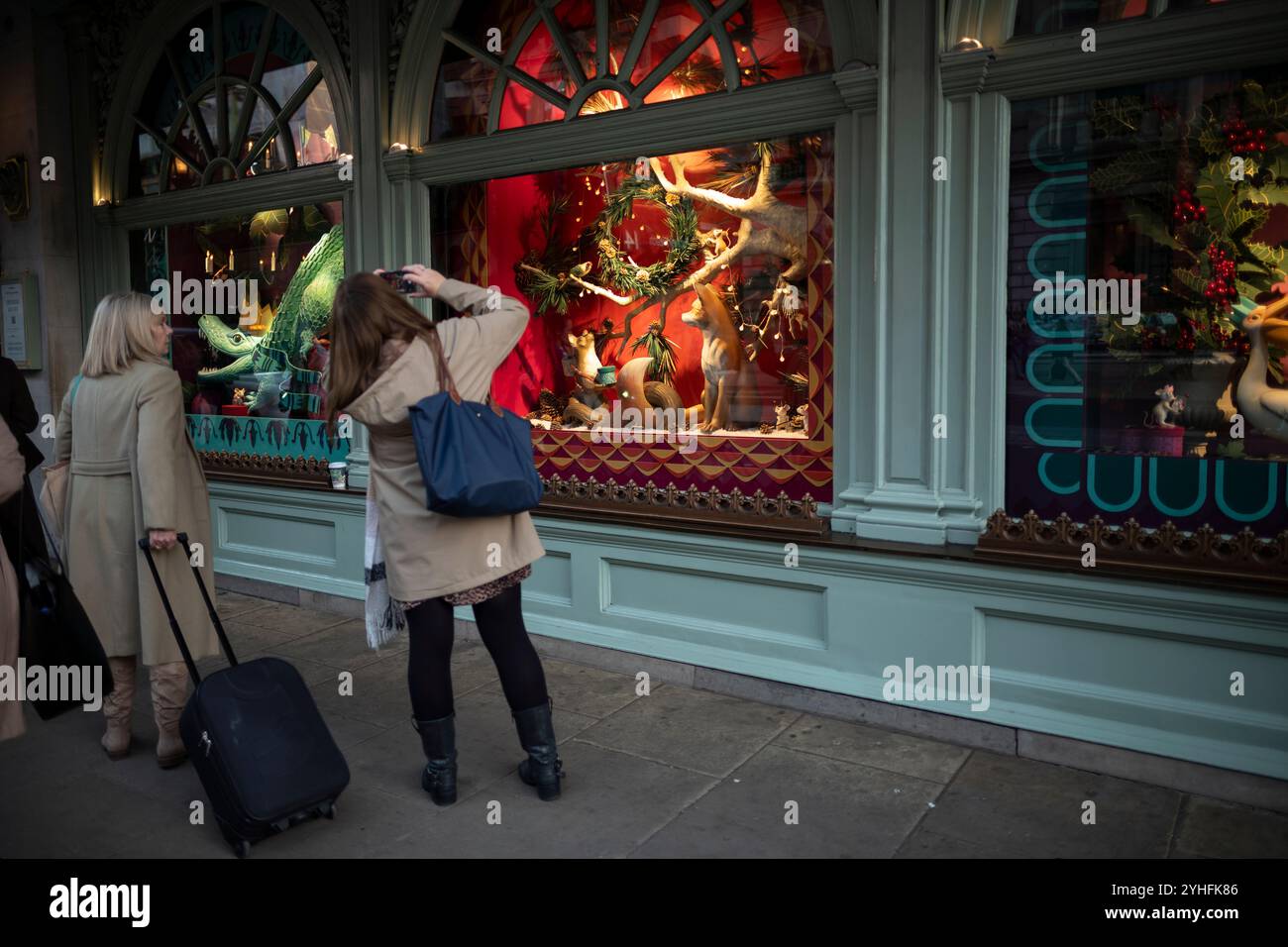 Touristen versammeln sich um das Fortnum & Mason Christmas 2024 Schaufenster, das sich auf Piccadilly, Mayfair, im Herzen von London, England, Großbritannien befindet Stockfoto