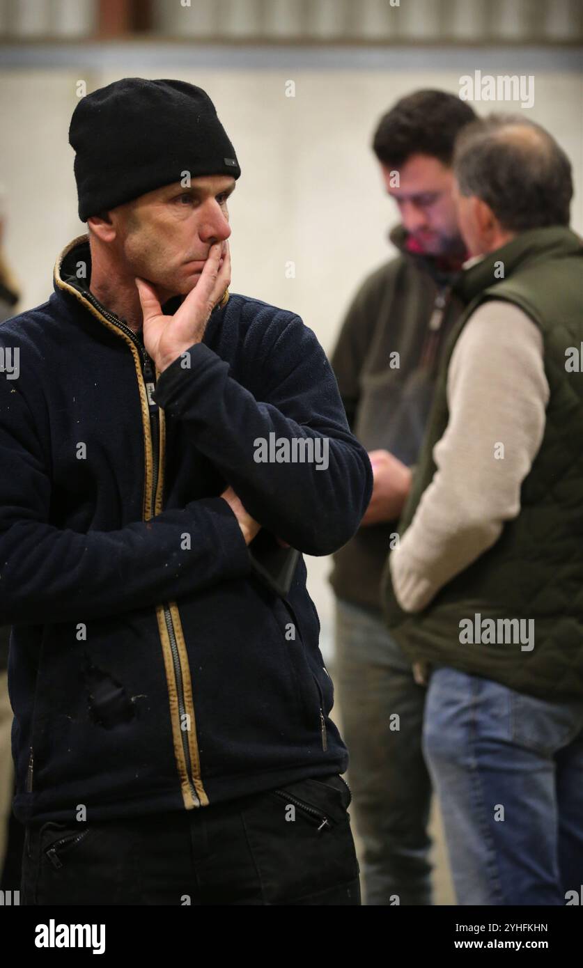 März, England, Großbritannien. November 2024. Ein Fönlandwirt schlägt eine besorgte Pose ein, als er sich in einem Traktorschuppen auf der Riverside Farm mit anderen Bauern trifft, um einen Aktionsplan nach den jüngsten Änderungen der Erbschaftssteuer durch die Labour-Regierung zu besprechen. Der Farmer TIM TAYLOR hat eine Kampagne für Bauern gegründet, die mit der zahnlosen National Farmers Union konkurrieren soll. Seine Gruppe zielt darauf ab, die Landbevölkerung zusammenzubringen und ihre Lebensweise zu bewahren. Sie sprechen von extremen Maßnahmen wie der Blockierung von Straßen und Häfen und der Lieferung von Waren an Supermärkte nach der Entscheidung der Labour Party Stockfoto