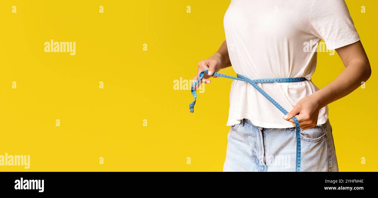 Unerkennbare Frau in weißem T-Shirt mit dünner Taille und Klebeband Stockfoto