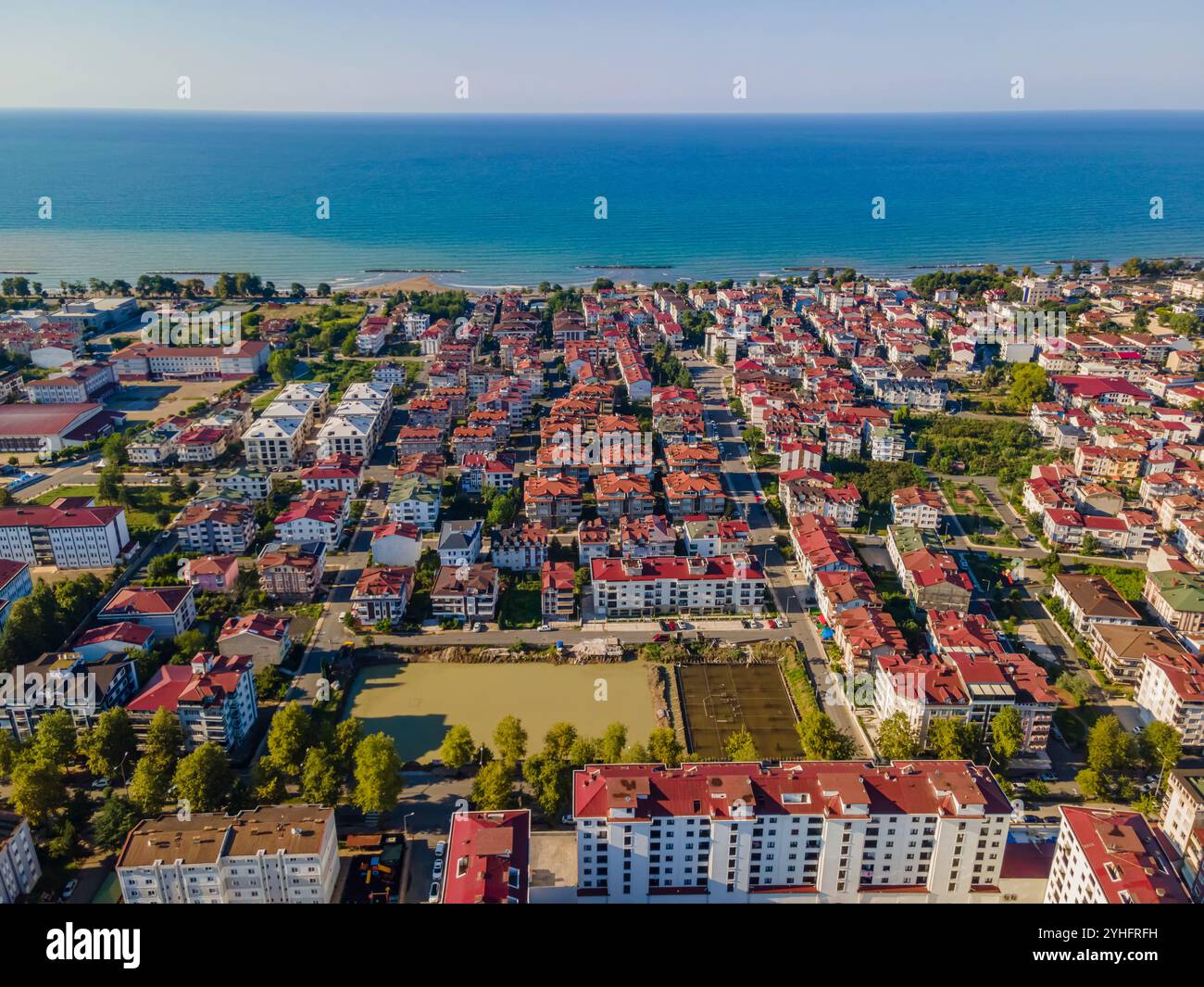 Blick auf die Stadt mit einem großen Wasserfeld in der Mitte. Das Feld ist von Gebäuden und Bäumen umgeben Stockfoto