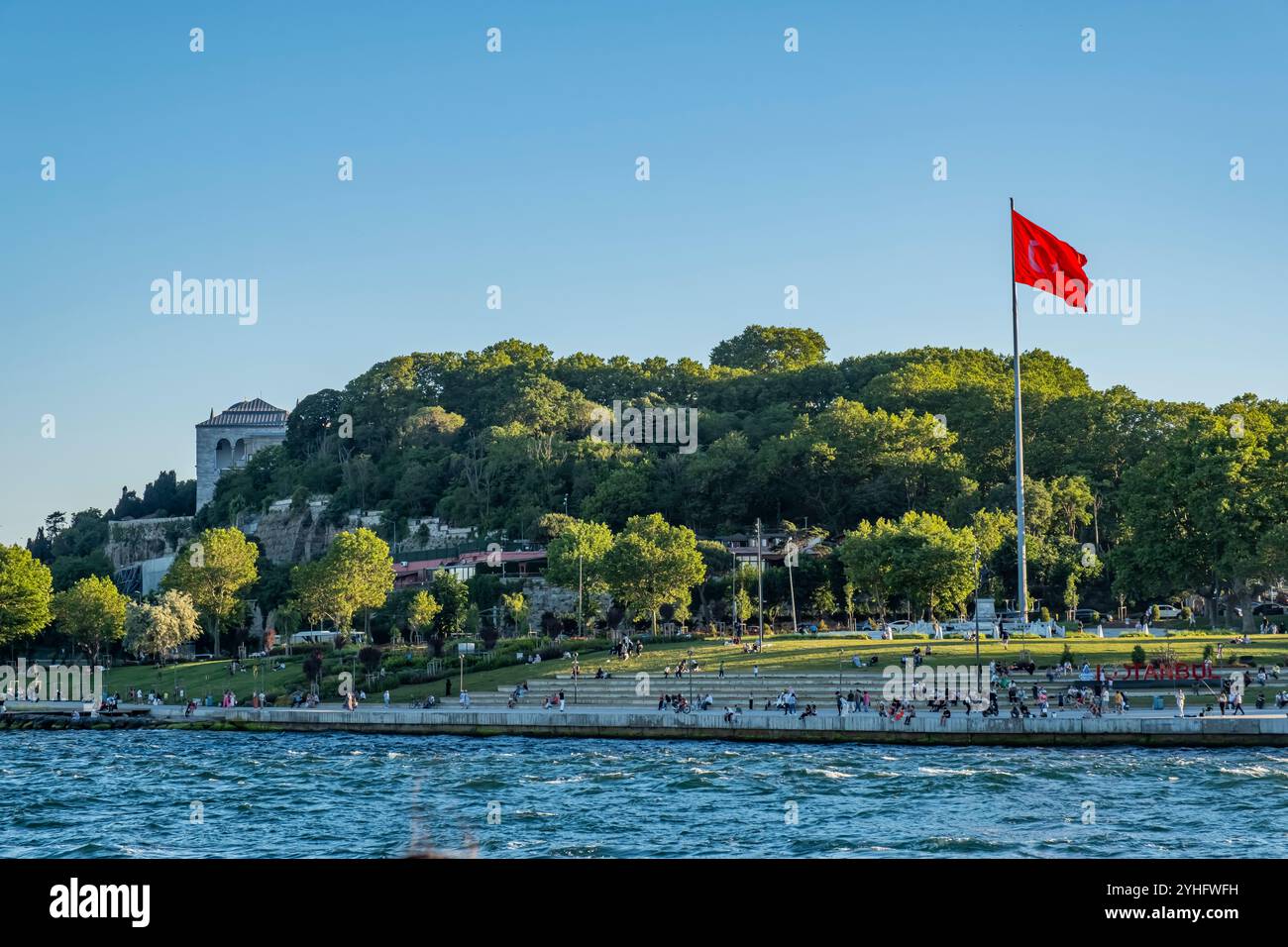 Die Bäume des gulhane-Parks neben dem Topkapi-Palast sind grün und haben eine große türkische Flagge Stockfoto