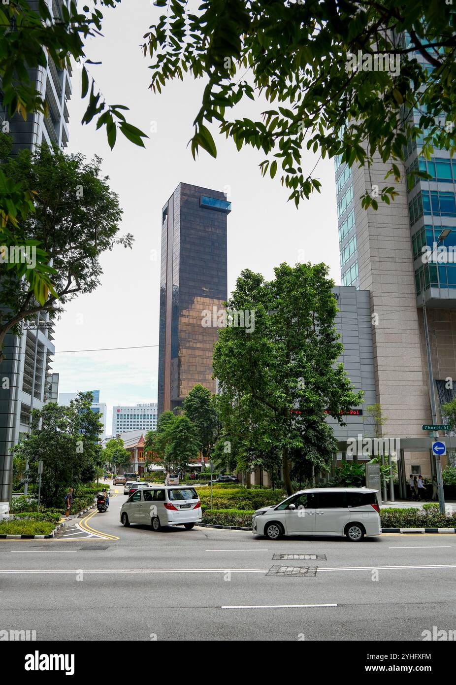 Der goldbraune Wolkenkratzer des Clan Hotel hebt sich vom Grün der Stadtlandschaft Singapurs ab. Stockfoto