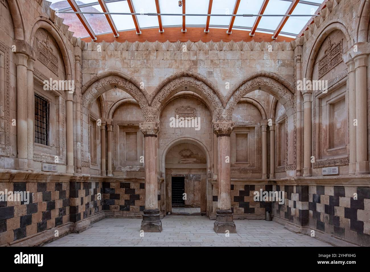 Das Innere eines Gebäudes mit Bogenfenstern und Säulen. Das Gebäude ist leer und die Säulen sind braun. Ishakpasa Palast in der Stadt Agri Dogubeyazit, Stockfoto