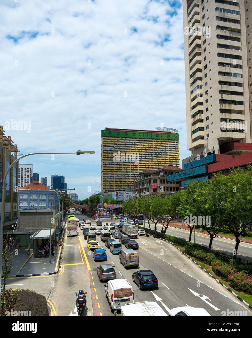 Ein Blick auf die New Bridge Road in Richtung des Peoples Park Wahrzeichen HDB Gebäude mit Straße und Verkehr im Vordergrund gesäumt von Bäumen. Stockfoto