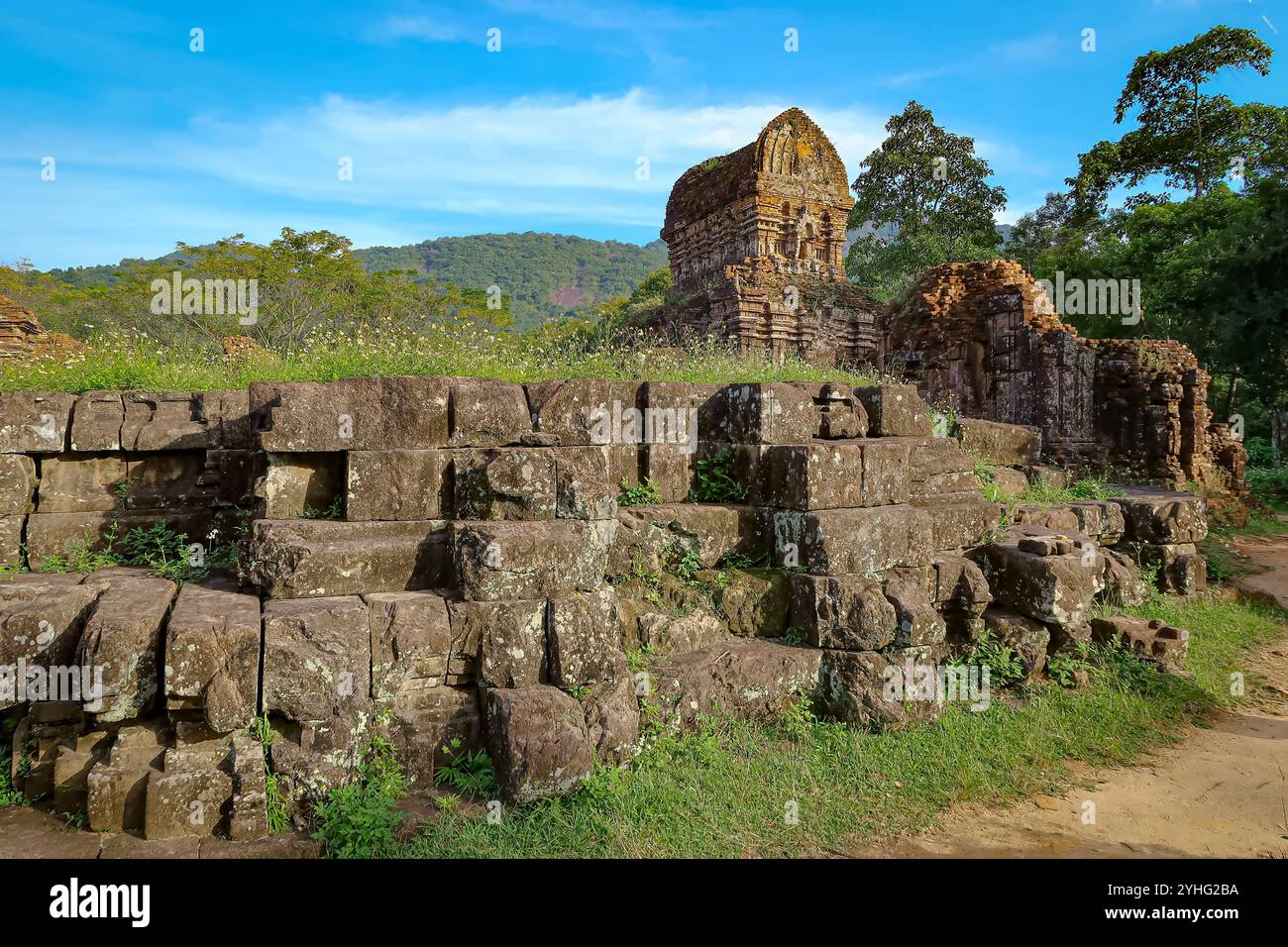 Alte Steinruinen, die mit viel Grün bewachsen sind, in einer ruhigen natürlichen Landschaft, die verwitterte Architektur und historische Überreste zeigt. Stockfoto