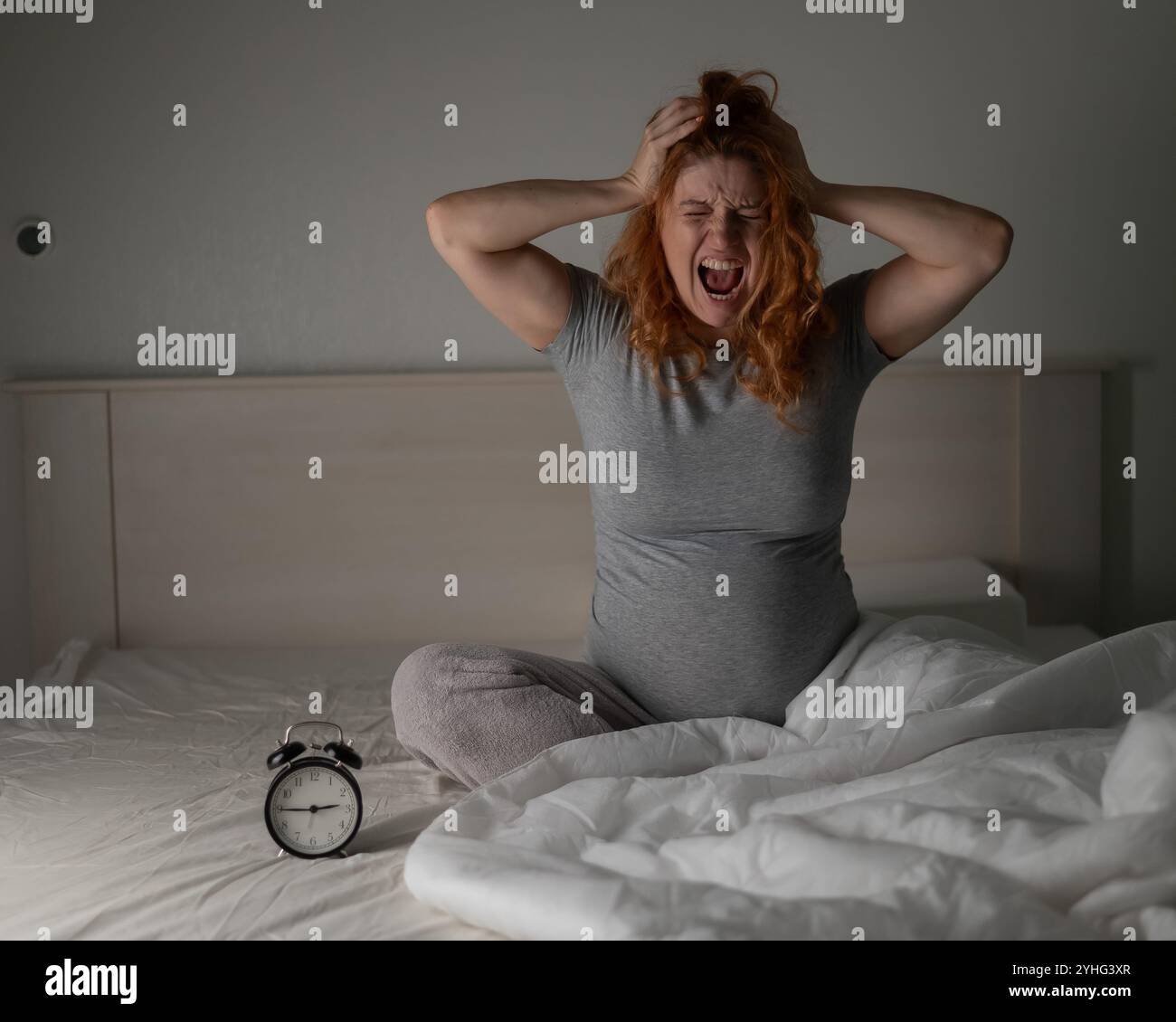 Kaukasische Schwangere sitzend und schreiend, während sie an Schlaflosigkeit litt. Stockfoto