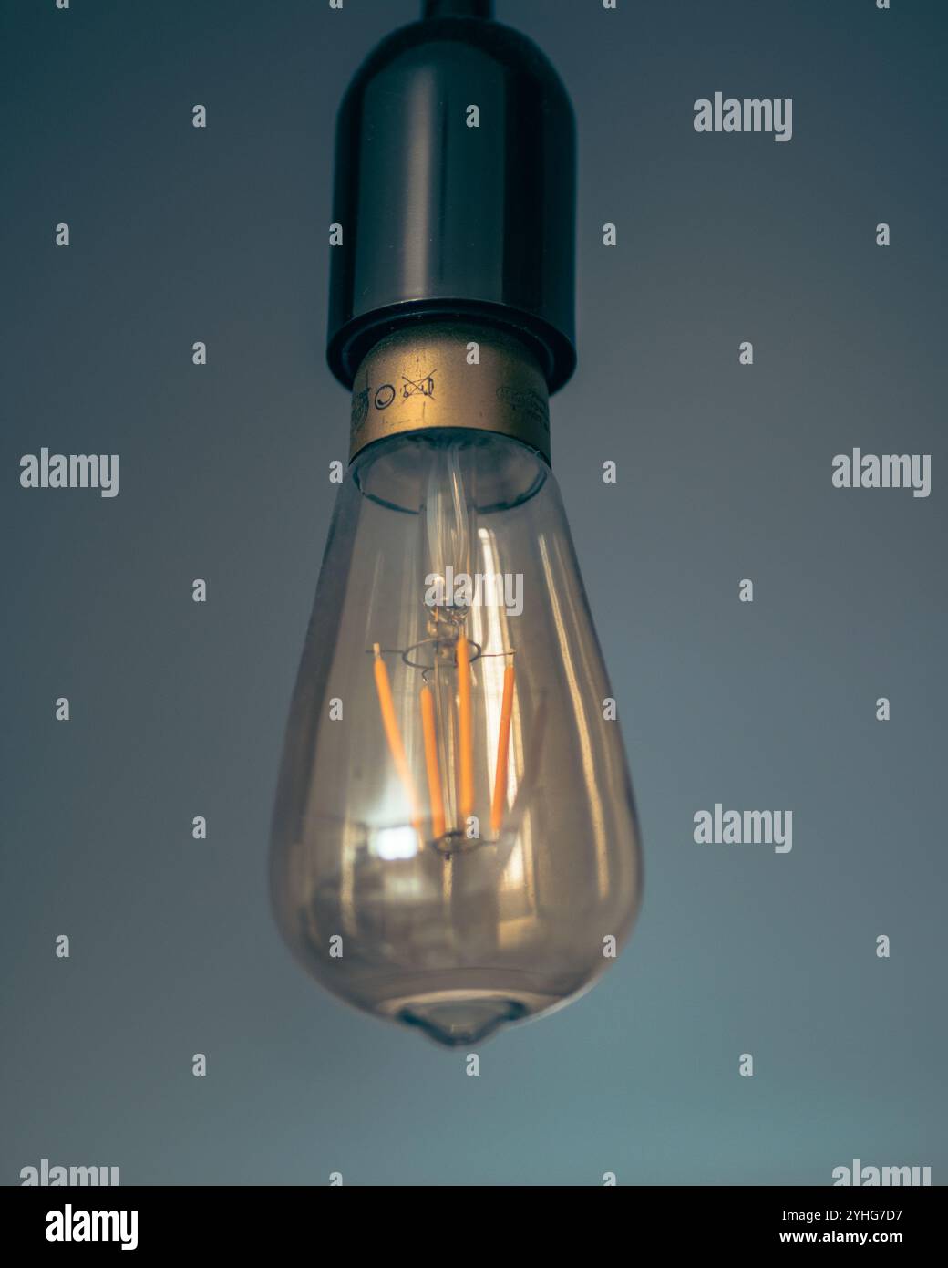 Dieses hochwertige Bild verfügt über eine gelbe LED-Leuchte, die einen Vintage-Stil nachahmt. Die Lampe hängt an der Decke und zeigt ihre Stockfoto