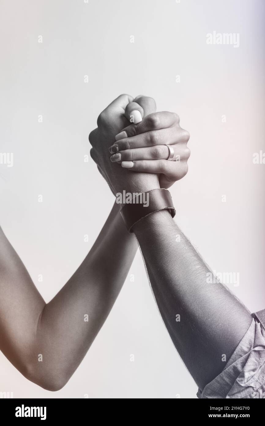Die gefalteten Hände repräsentieren einen subtilen, aber kraftvollen „Kampf der Geschlechter“. Was freundlich erscheint, hält einen zugrunde liegenden Kampf um Gleichgewicht und Stärke i Stockfoto
