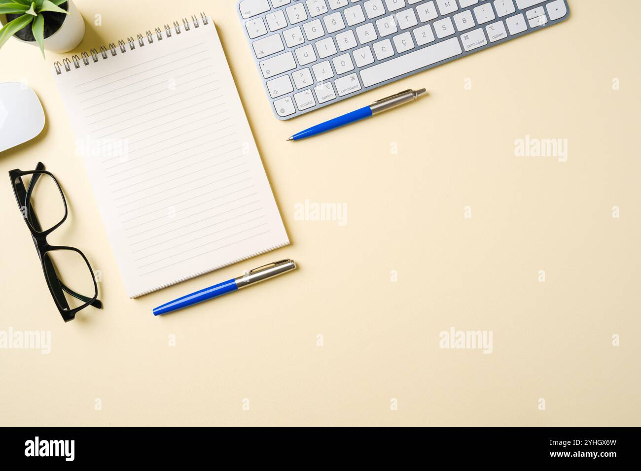 Schreibtisch mit Computertastatur, Maus, Brille, Notebook und Stift. Draufsicht mit Kopierbereich. Flache Lagen Stockfoto