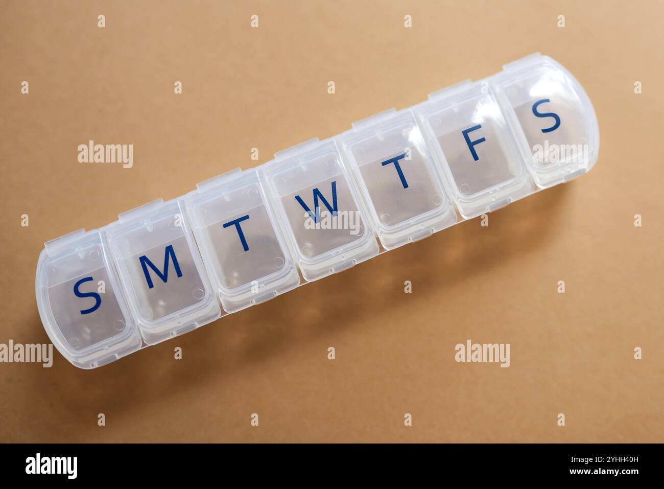 Leer, Woche oder Behälter mit Tagen für Medikamente, Routine- oder Tagesdosis oben im Studio auf braunem Hintergrund. Draufsicht, Nahaufnahme oder Halter für Pille Stockfoto