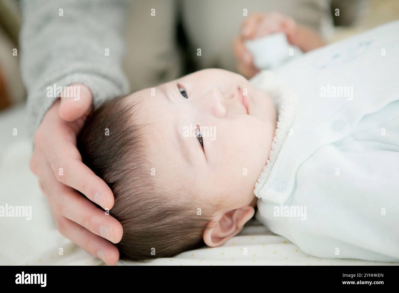 Vater klopft Baby auf den Kopf Stockfoto