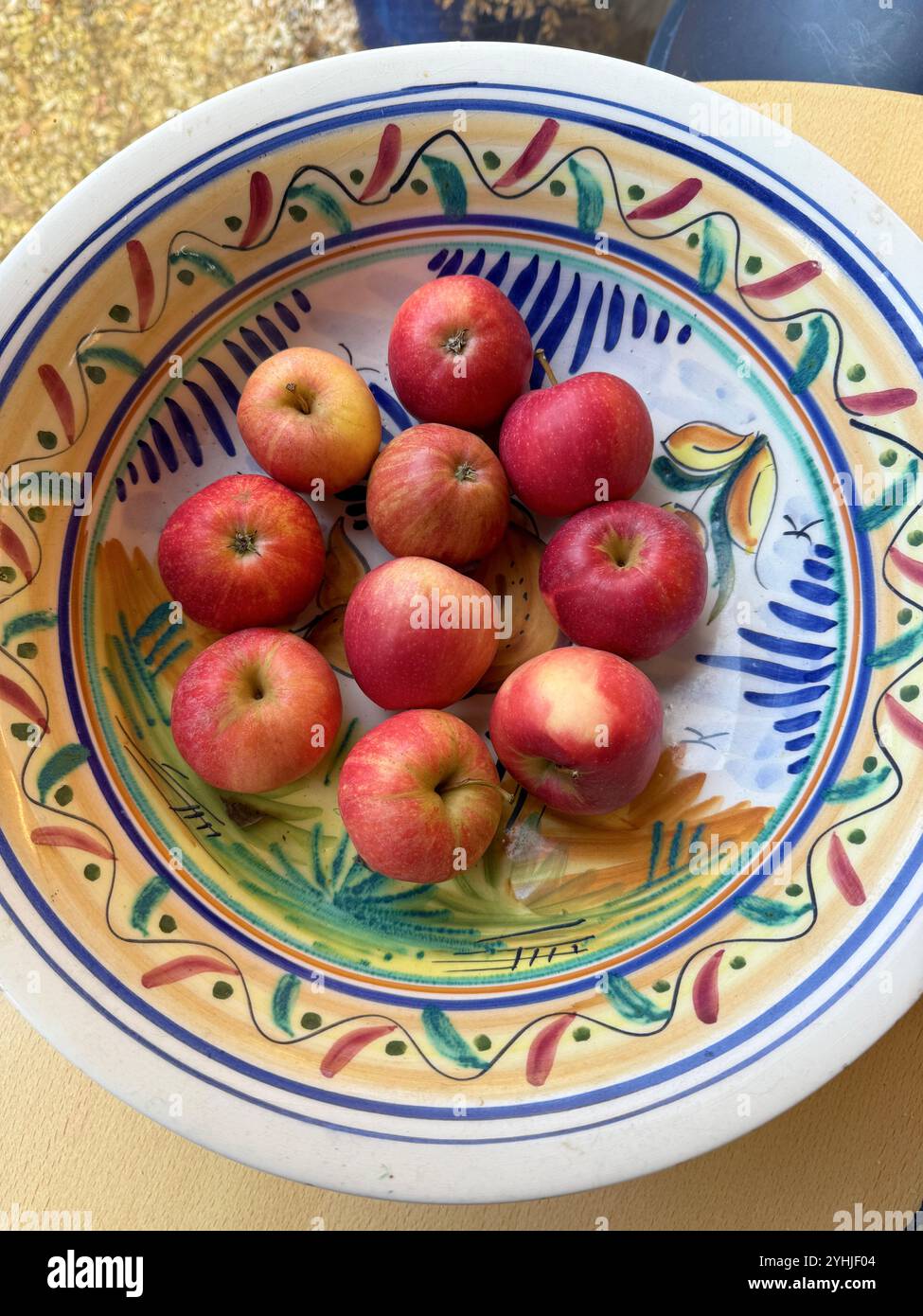 Rote Äpfel in einer farbenfrohen spanischen Schüssel Stockfoto