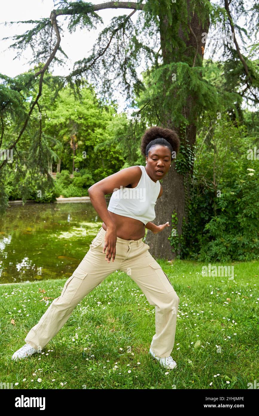 Eine Afrikanerin spielt Hip-Hop-Tanzschritte im Freien und zeigt ihre Energie und ihr Können in einer lebendigen und lebendigen Umgebung. Stockfoto