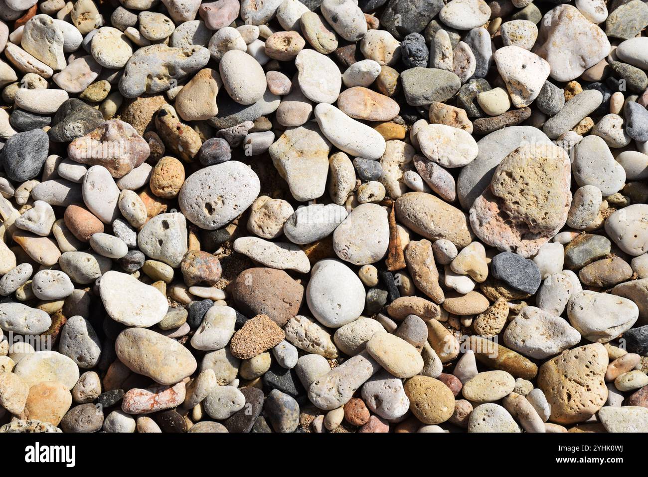 Kieselsteine am Strand, glatte Strandsteine, Küstensteine, Strandsteinmuster, bunte Kieselsteine, Kieselküsten, Steine am Meer, Kieselsteinen Stockfoto