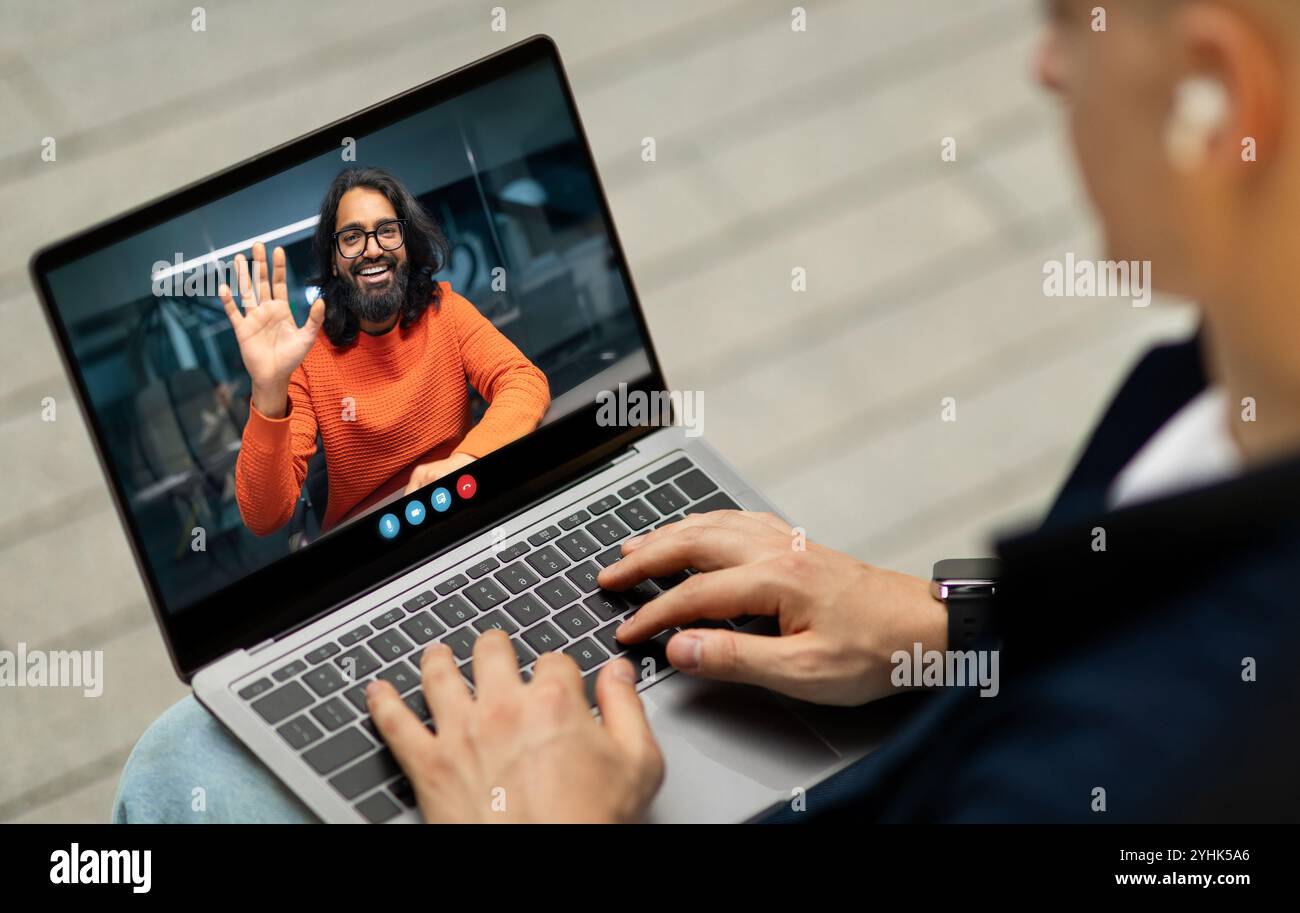 Person, die mit einer lächelnden Person in einem orangefarbenen Pullover einen Videoanruf führte Stockfoto