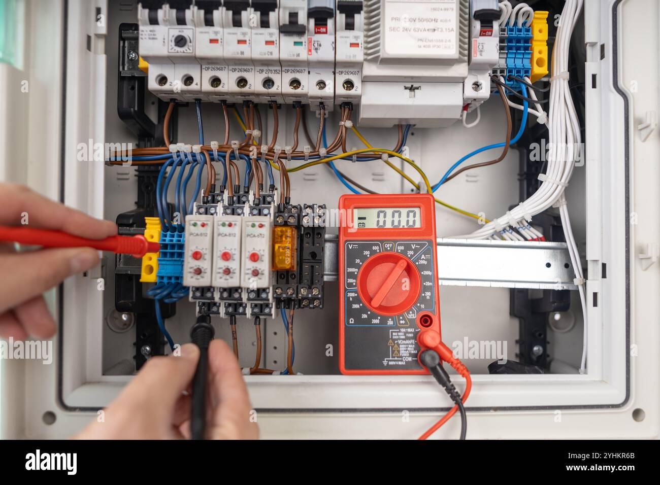 Techniker, der die elektrische Leiterplatte mit Multimeter prüft Stockfoto