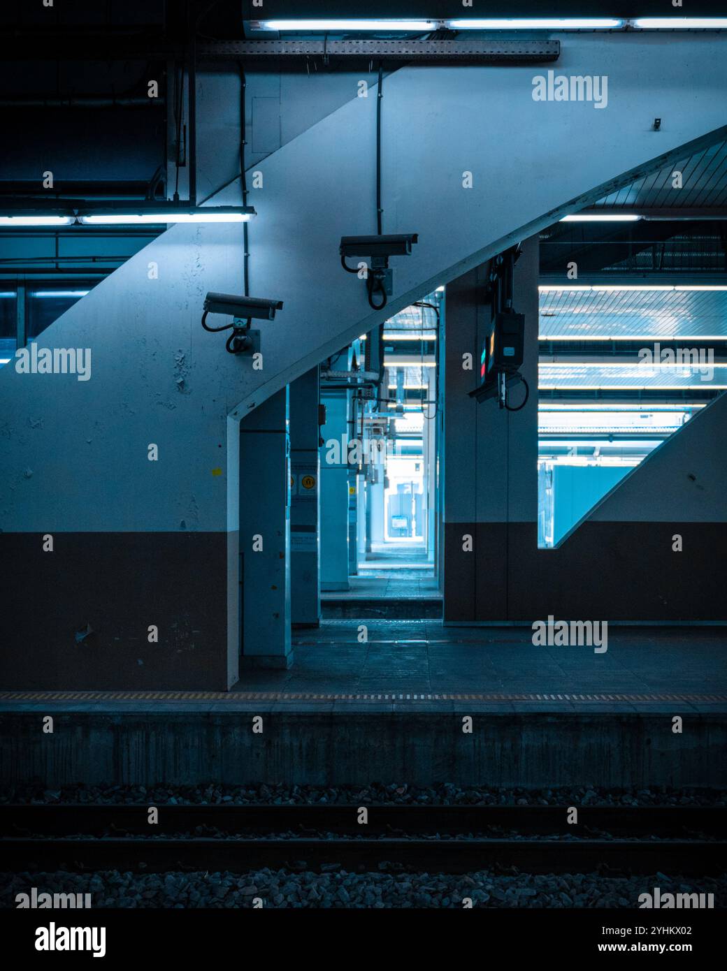 Schwach beleuchtete Bahnsteige mit Überwachungskameras Stockfoto